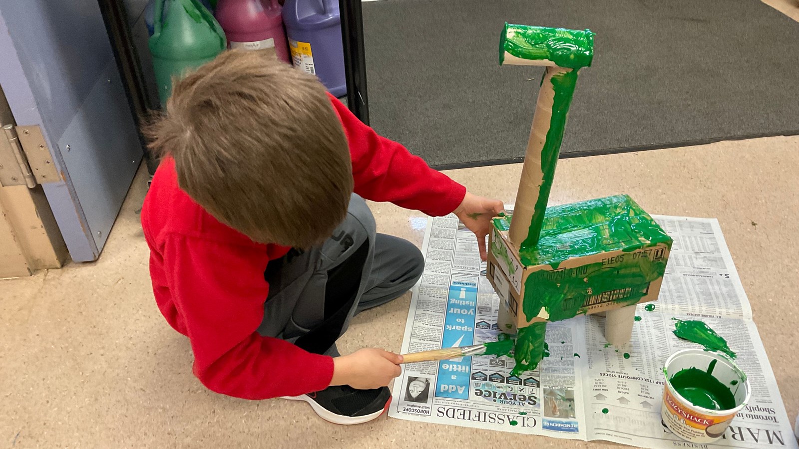A Quadra student paints his Not A Box Creation ahead of the school's art show.